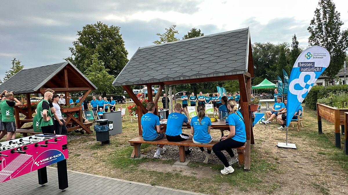 Personen sitzen auf einer bank mit überdachung