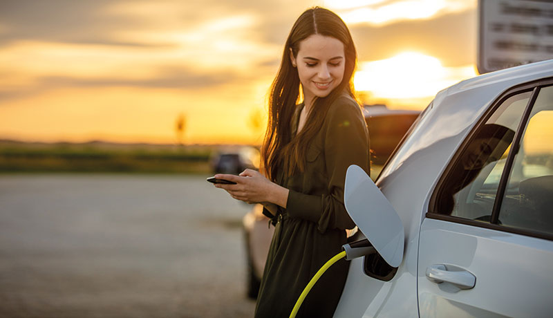 Frau lädt ihr E-Auto